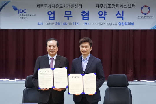 김한욱 제주국제자유도시개발센터(JDC) 이사장(왼쪽)이 전정환 제주창조경제혁신센터 센터장과 14일 오전 JDC본사에서 창업생태계 활성화를 위한 업무협약을 체결한 뒤 기념 촬영하고 있다.  제주창조경제혁신센터 제공